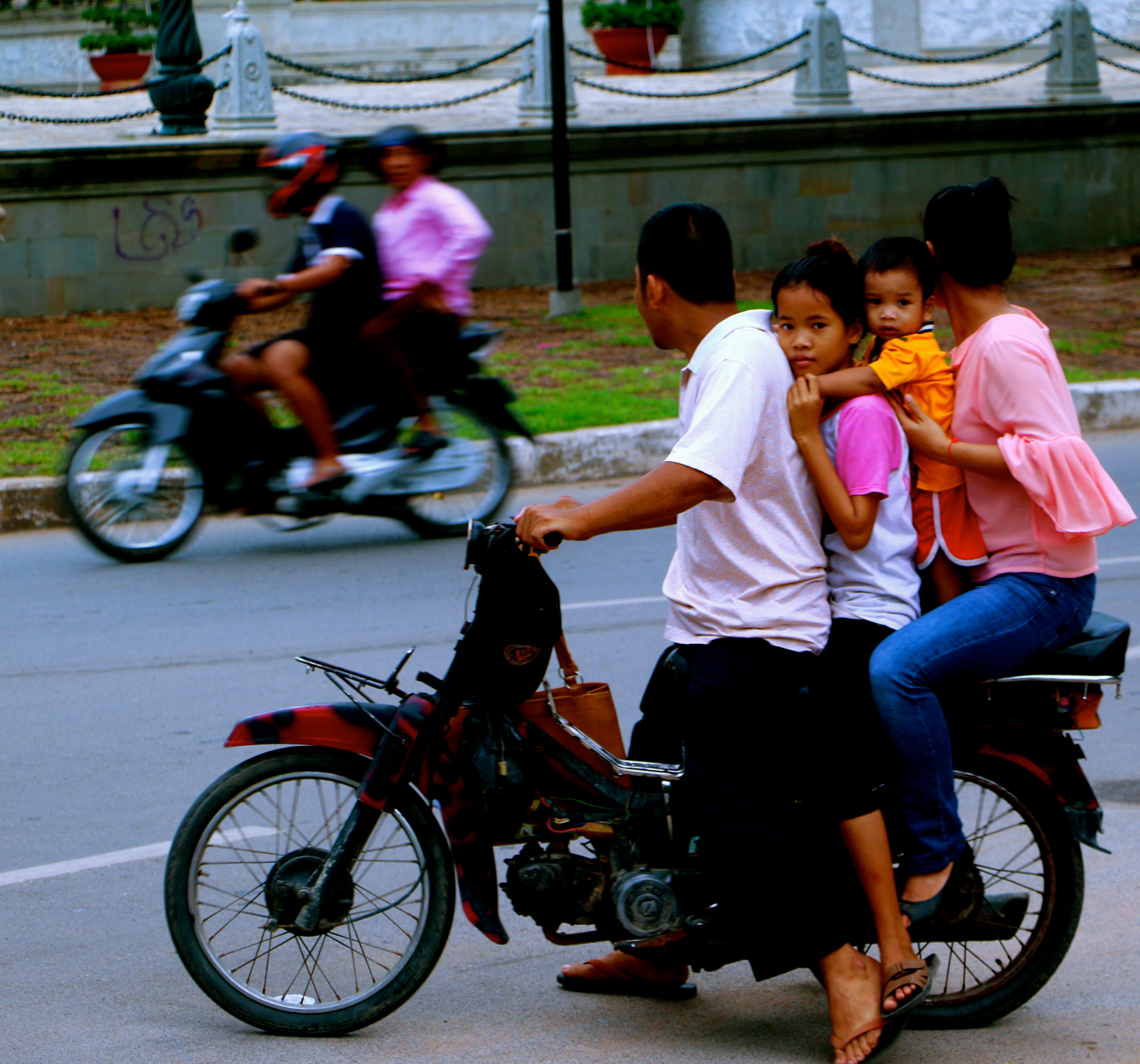 A family traveling together on the most popular means of transport in Cambodia.